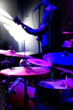 Image of band playing music under indigo lights